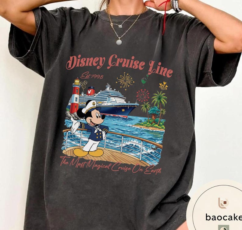 K&ouml;nnte beinhalten: Dunkelgraues T-Shirt mit einer farbenfrohen Grafik von Mickey Mouse auf einem Kreuzfahrtschiff. Das Design enth&auml;lt den Text "Disney Cruise Line" und "The Most Magical Cruise On Earth". Das T-Shirt hat einen Vintage-Look.