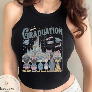 May include: Black tank top with a colorful graphic featuring Disney characters in graduation attire in front of a castle. The word "Graduation" is printed in blue above the castle and graduation caps.