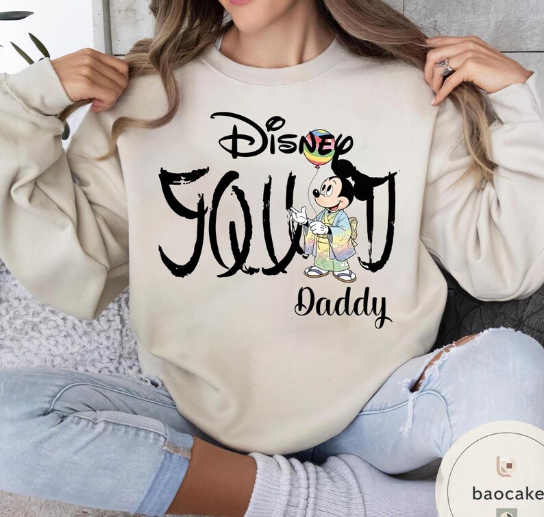 Puede incluir: Sudadera beige con la frase "Disney Soul Daddy" en negro. El dise&ntilde;o incluye un gr&aacute;fico de Mickey Mouse sosteniendo un globo arco&iacute;ris. La sudadera es de estilo casual y c&oacute;modo.