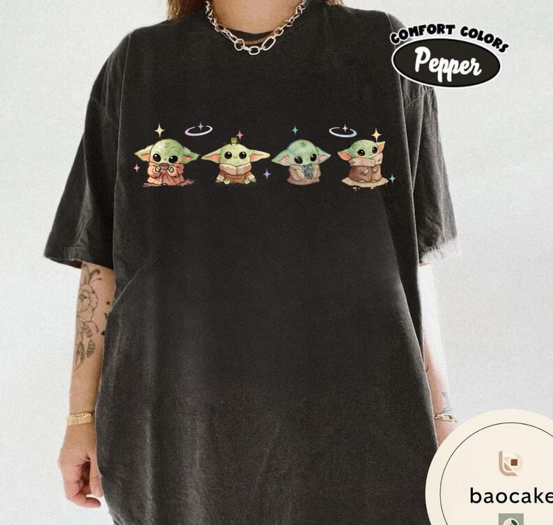 May include: Black t-shirt featuring four cartoon characters with large eyes and pointed ears. Each character is wearing a different outfit. The text "Comfort Colors Pepper" is in a white oval on the upper right.