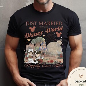 May include: Black t-shirt featuring a graphic of Mickey and Minnie Mouse in wedding attire in front of Disney World landmarks. Text reads "JUST MARRIED EST 2026 Disney World Happily Ever After."