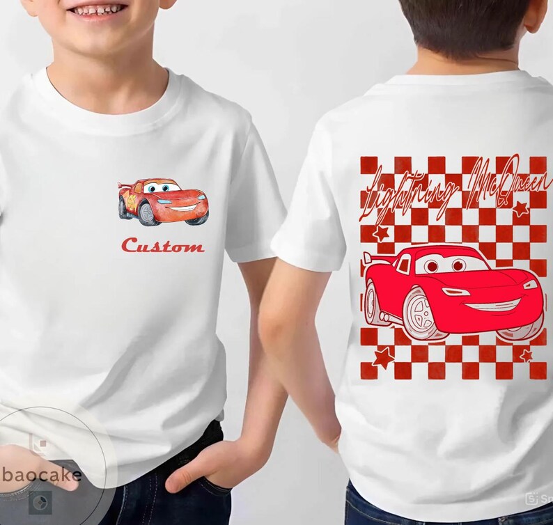 May include: White t-shirt featuring a cartoon image of a red race car with the text "Custom" on the front. The back of the shirt has a red and white checkered pattern with the words "Lightning McQueen" and a red race car.