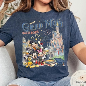 May include: Navy blue t-shirt with a colourful graphic featuring the text "Grad Mom Class of 2026" and a Disney castle. The graphic includes Mickey Mouse, Minnie Mouse, Donald Duck, and Goofy in graduation attire.