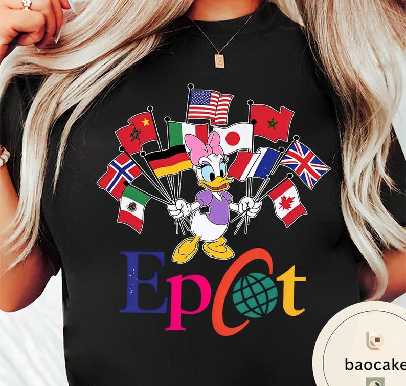 May include: Black t-shirt with a cartoon of Daisy Duck holding flags from different nations. The word "Epcot" is printed in colourful letters below the character, with a globe graphic. A fun and colourful design.