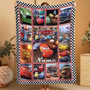 May include: A rectangular fleece blanket featuring a collage of various characters from the movie Cars, including Lightning McQueen and Mater. The design is bordered by a black and white checkered pattern and includes the text Cars and Name.