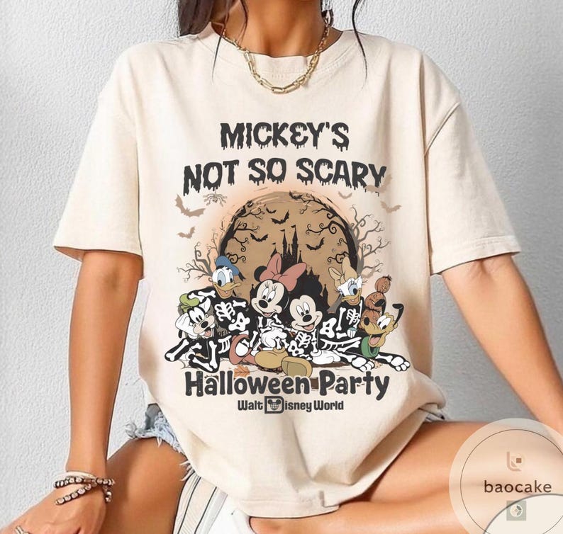 May include: Beige t-shirt featuring a Halloween-themed graphic. The design includes Mickey Mouse, Minnie Mouse, Donald Duck, and Goofy in skeleton costumes, with the text "Mickey's Not So Scary Halloween Party" and "Walt Disney World".