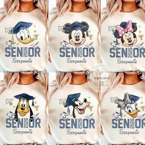 May include: Cream-colored t-shirts featuring Disney characters wearing graduation caps. Each shirt has "SENIOR 2026" and a name printed below. Donald Duck, Mickey Mouse, Minnie Mouse, Goofy, and Daisy Duck are shown.