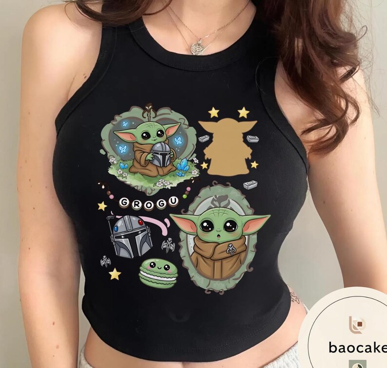 May include: A black sleeveless tank top featuring a graphic print of the character Grogu in various poses, including inside a decorative frame and holding a helmet. The design includes small stars, a green macaron, and the text GROGU in white.