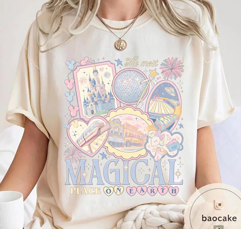 May include: Cream-coloured t-shirt with a pastel graphic featuring a castle, Spaceship Earth, and other theme park imagery. The text "MAGICAL PLACE ON EARTH" is displayed in blue and pink lettering, creating a whimsical aesthetic.