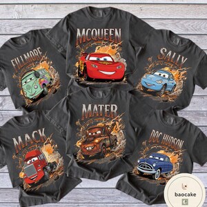May include: Six charcoal grey t-shirts featuring characters from the film Cars. Each shirt displays a different character: McQueen, Sally, Mater, Doc Hudson, Mack, and Fillmore, with their names above the images.