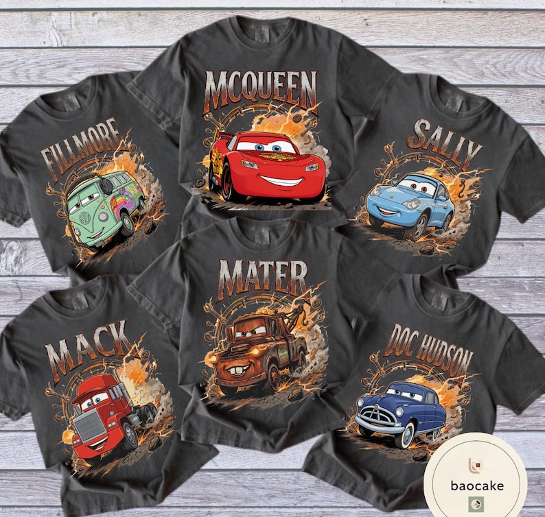 May include: Six charcoal grey t-shirts featuring characters from the film Cars. Each shirt displays a different character: McQueen, Sally, Mater, Doc Hudson, Mack, and Fillmore, with their names above the images.