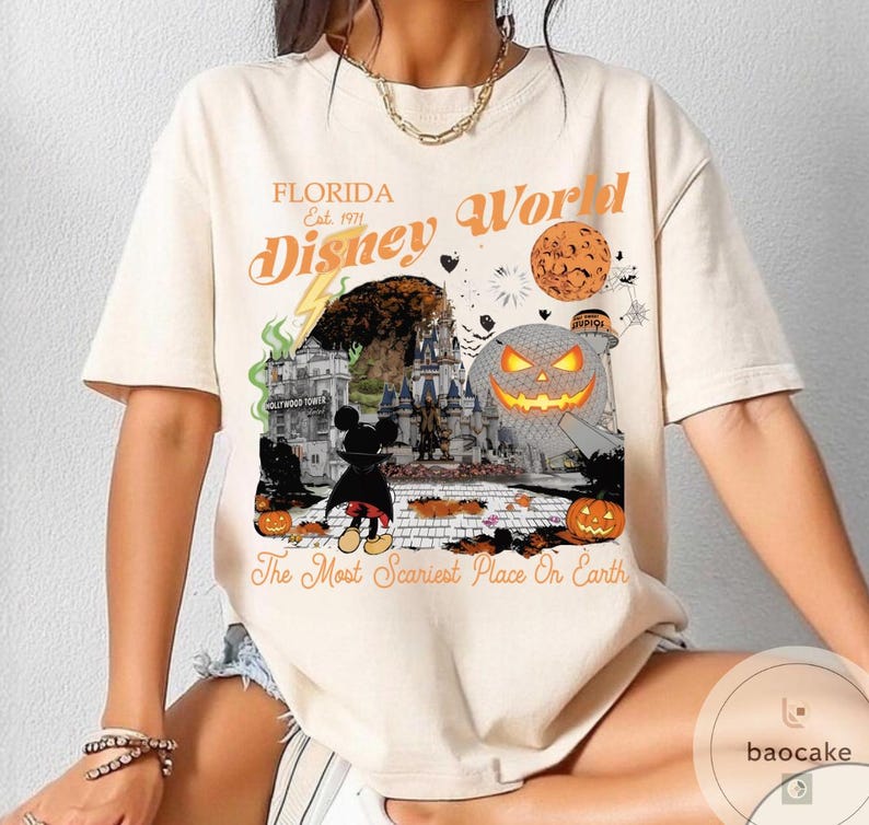 May include: Cream-colored t-shirt featuring a Halloween-themed Disney World graphic. The design includes a pumpkin, Mickey Mouse, and the text "Florida Disney World" and "The Most Scariest Place On Earth."
