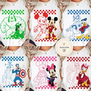 May include: White t-shirts featuring cartoon characters. Designs include Hulk and Pluto in green, Mickey Mouse and Iron Man in red, Spider-Man and Donald Duck in blue, Goofy and Captain America in blue, Minnie Mouse in pink, and Daisy Duck in red.