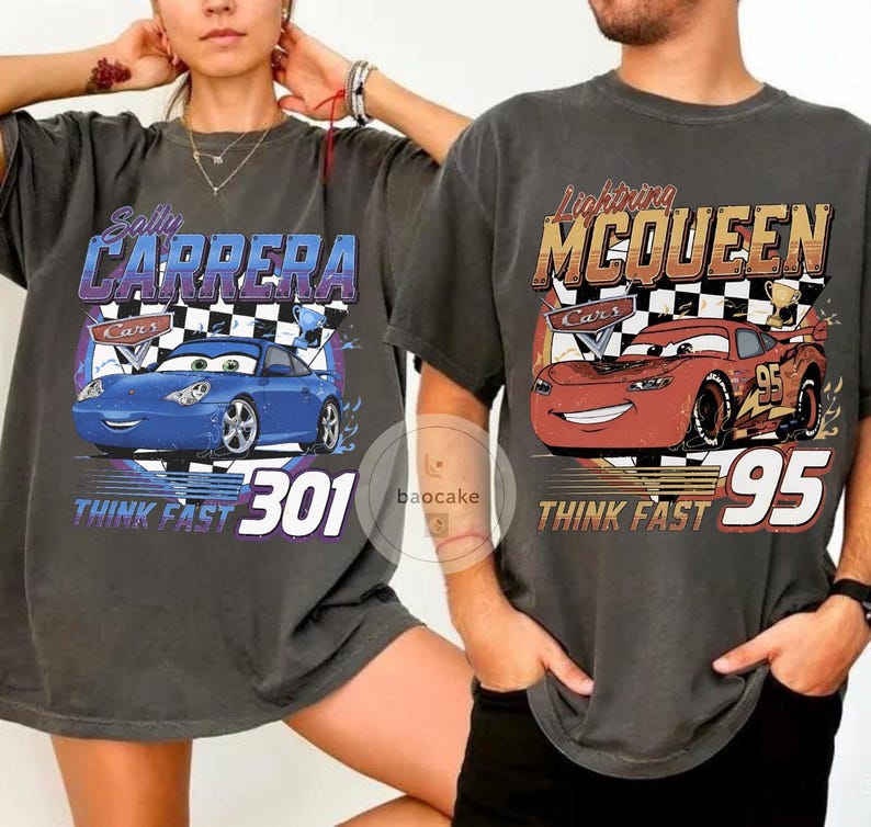 Puede incluir: Dos camisetas gris carb&oacute;n con gr&aacute;ficos de la pel&iacute;cula "Cars". Una camiseta muestra un coche azul con el texto "Sally Carrera" y "Think Fast 301". La otra camiseta muestra un coche rojo con "Lightning McQueen" y "Think Fast 95."