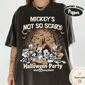 May include: Dark gray t-shirt featuring a Halloween-themed graphic. The design includes the text "Mickey's Not So Scary Halloween Party" with Disney characters in skeleton costumes. The shirt has a Comfort Colors Pepper label.