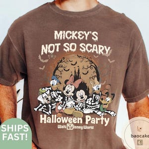 May include: Brown t-shirt featuring a Halloween design with Mickey Mouse, Minnie Mouse, Donald Duck, and Goofy dressed as skeletons. The shirt has the text "Mickey's Not So Scary Halloween Party" and "Walt Disney World".