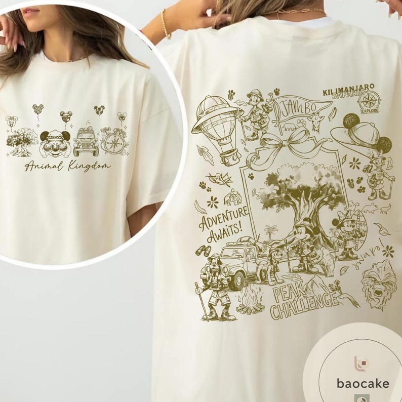 May include: Cream-colored t-shirt featuring a detailed graphic design. The front displays "Animal Kingdom" with themed illustrations. The back showcases a safari adventure scene with text that reads "Adventure Awaits!" and "Kilimanjaro Safaris".