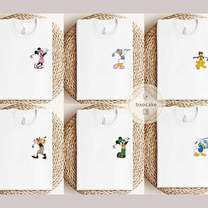 May include: White t-shirts with various cartoon characters playing golf. Characters include Minnie Mouse, Donald Duck, Pluto, Goofy, and Mickey Mouse. Each shirt features a small, colorful graphic on the chest.
