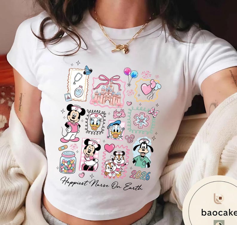 May include: White t-shirt featuring colorful cartoon illustrations of Disney characters in nurse attire, including Mickey and Minnie Mouse, Donald Duck, and Goofy. The shirt includes the text "Happiest Nurse On Earth" and the year "2026".
