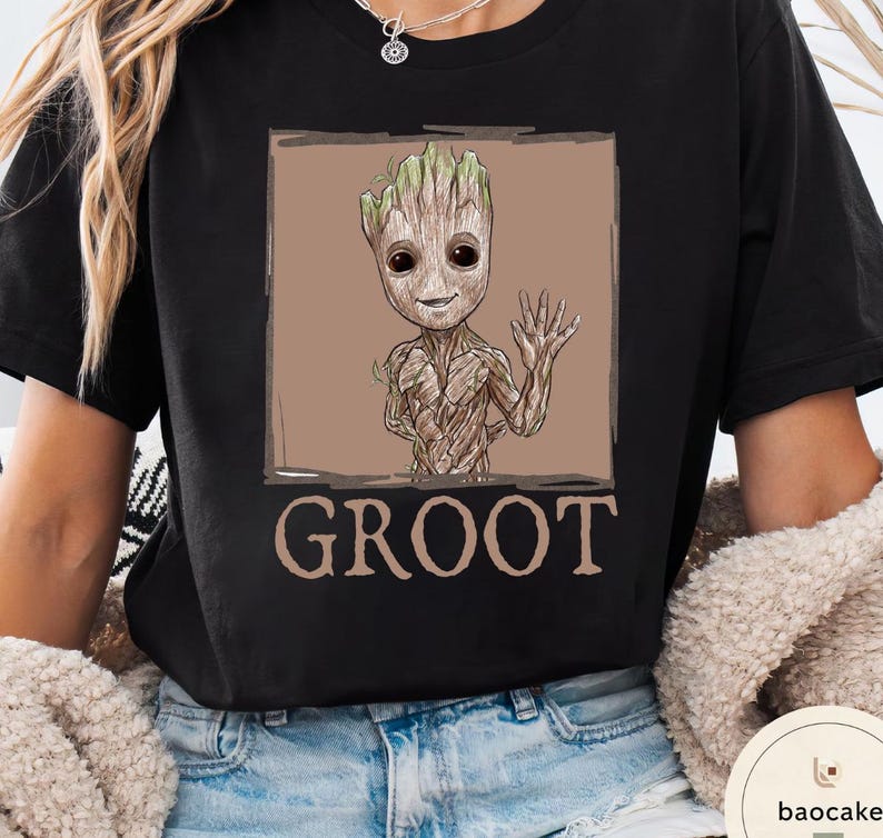 May include: Black t-shirt featuring a Groot graphic from Guardians of the Galaxy. The design shows Groot waving with a brown background and the word "GROOT" below. The shirt is a comfortable, casual style.