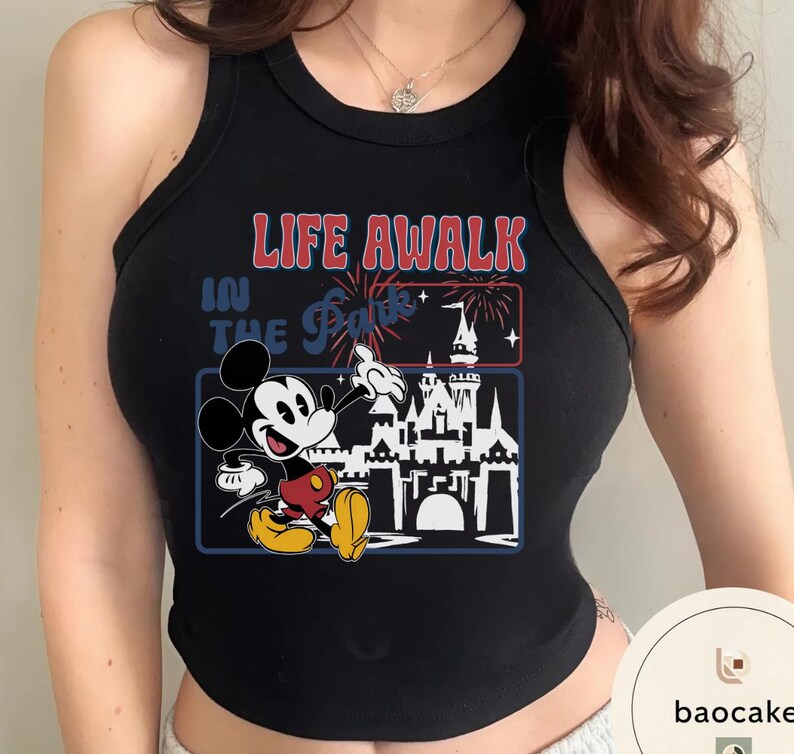 May include: Black vest top with a graphic of Mickey Mouse and a castle, with the text "LIFE AWALK IN THE Parks". The design incorporates red, blue, and yellow.