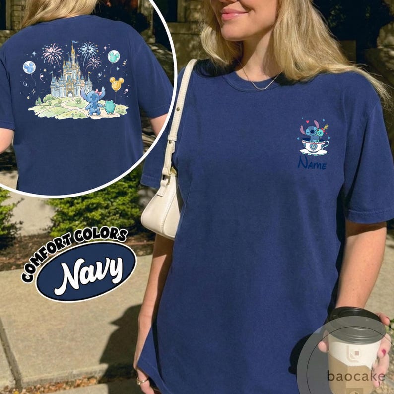 May include: Navy blue t-shirt with a cartoon graphic of a character in a teacup, with the word "Name" below. The back of the shirt features a castle, fireworks, and character graphics. The shirt is labeled "Comfort Colors Navy".