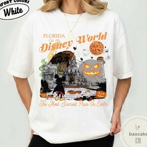 May include: White t-shirt with a Halloween-themed graphic featuring the text "Florida Disney World" and a spooky design. The graphic includes a jack-o'-lantern, Mickey Mouse, and the phrase "The Most Scariest Place On Earth."
