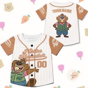 May include: White and brown baseball jersey with the text "Nibbles Maplestick" and a cartoon beaver graphic. The jersey has brown sleeves and a button-up front. The number "00" is on the front.