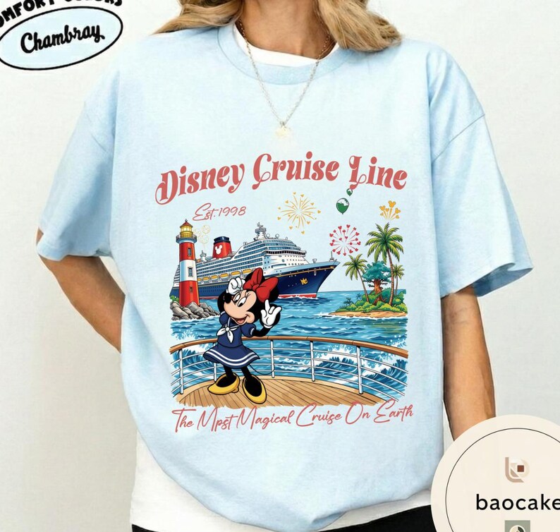 K&ouml;nnte beinhalten: Hellblaues T-Shirt mit einem Disney Cruise Line-Motiv. Das Design zeigt Minnie Mouse auf einem Kreuzfahrtschiff, mit dem Text "Disney Cruise Line Est. 1998" und "The Most Magical Cruise On Earth". Das T-Shirt hat einen Rundhalsausschnitt und kurze &Auml;rmel.