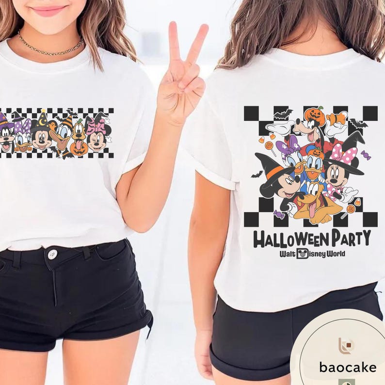 May include: White t-shirt featuring a Halloween-themed graphic with Disney characters. The front of the shirt displays a checkered pattern with cartoon characters. The back of the shirt has the words "Halloween Party" and more Disney characters.