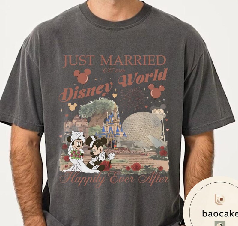 May include: Dark gray t-shirt featuring a Disney World design. The shirt has the words "Just Married Disney World" with Mickey and Minnie Mouse in wedding attire. The design includes a castle, Spaceship Earth, and roses.