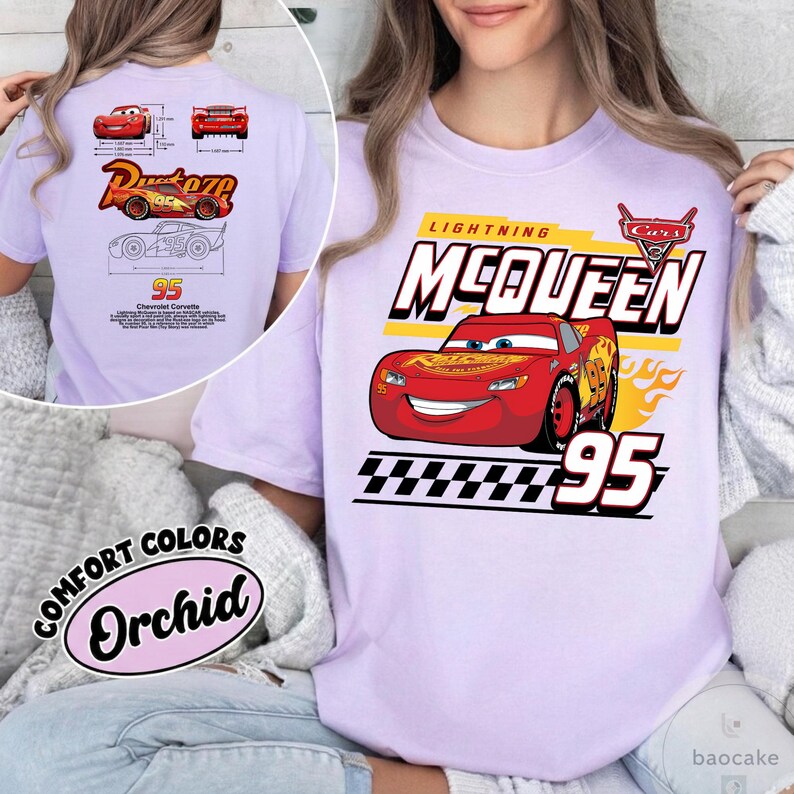 May include: A light purple t-shirt featuring a graphic of the red race car Lightning McQueen from the movie Cars. The design includes the text Lightning McQueen, the number 95, a checkered flag pattern, and the Cars logo in red and white.