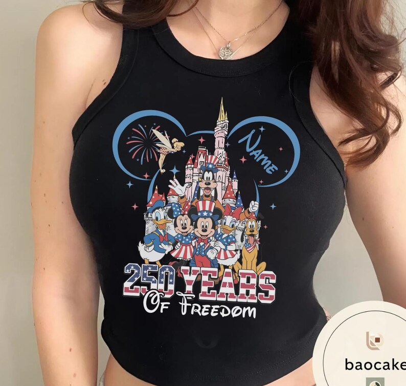 Peut inclure: D&eacute;bardeur noir avec un graphisme color&eacute; de personnages Disney, dont Mickey Mouse et Donald Duck, devant un ch&acirc;teau. Le texte "250 Years of Freedom" est affich&eacute; en dessous des personnages, avec un design bleu et rouge.