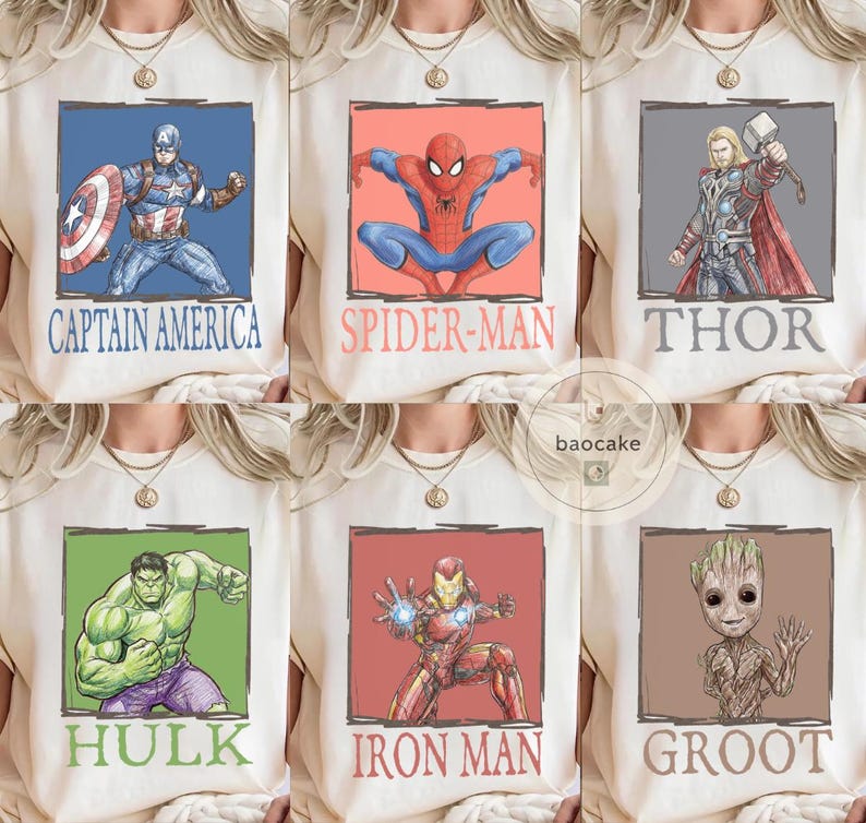 May include: Cream-colored t-shirts featuring superhero graphics. Designs include Captain America, Spider-Man, Thor, Hulk, Iron Man, and Groot, each within a colored frame and labeled with their name. The shirts have a round neckline.