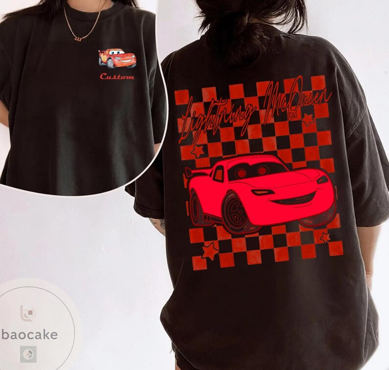 May include: Black t-shirt featuring a red cartoon car design. The front of the shirt has a small car graphic and the word "Custom". The back of the shirt has a larger car graphic with the words "Lightning McQueen" and a checkered background.