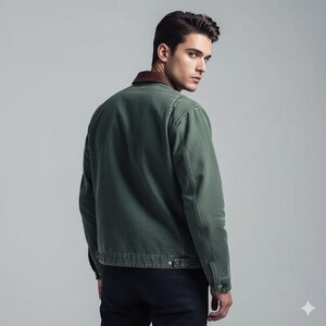 May include: A green jacket with a brown collar. The jacket has a classic design with a button closure and pockets. The model is wearing a dark blue pair of pants. The jacket is made of a durable material.