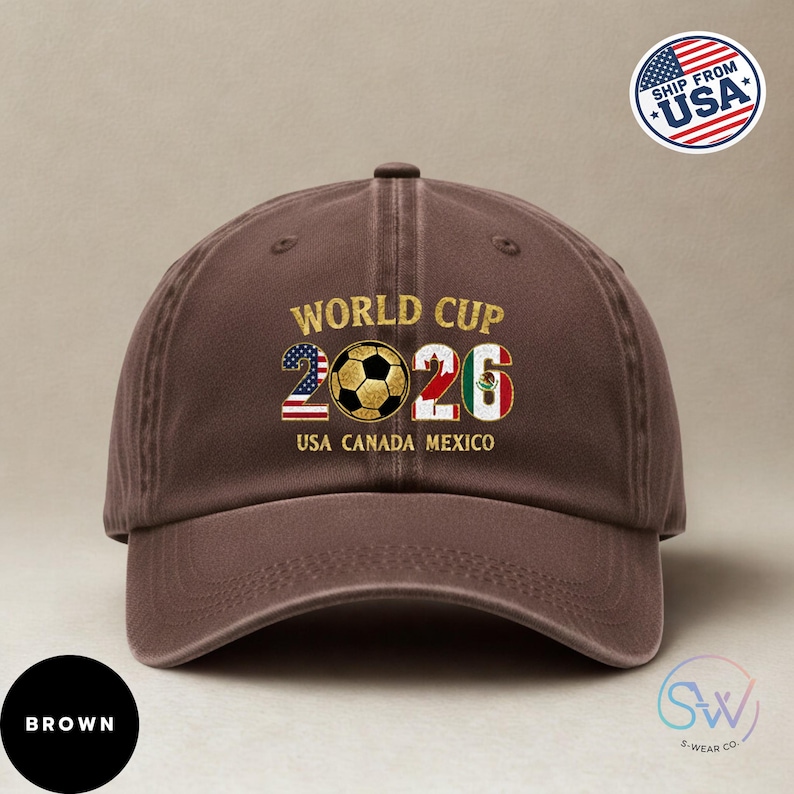 May include: A brown baseball cap featuring the text "WORLD CUP 2026" and a soccer ball graphic. The numbers 2026 incorporate the flags of USA, Canada, and Mexico. The cap also displays "USA CANADA MEXICO".