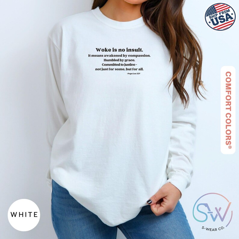 May include: White long-sleeve sweatshirt with the text "Woke is no insult" and a quote about compassion and justice. The sweatshirt is from Comfort Colors and has a "Ship from USA" graphic.