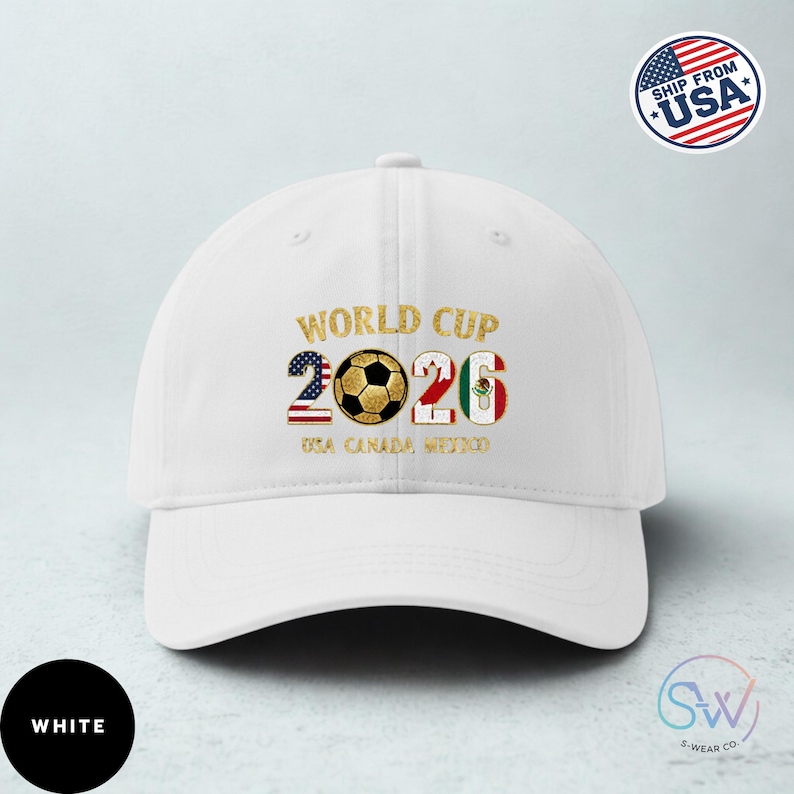 May include: White baseball cap featuring "WORLD CUP 2026" text and a soccer ball graphic. The numbers 2 and 6 incorporate the American and Mexican flags. The text "USA CANADA MEXICO" is below the numbers.
