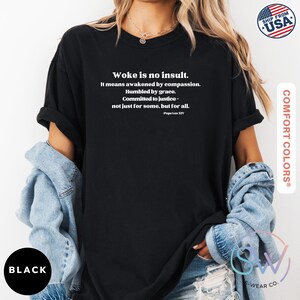 May include: Black t-shirt with the text "Woke is no insult." The text continues with a quote by Pope Leo XIV. The shirt is made by Comfort Colors and has a "Ship from USA" logo.
