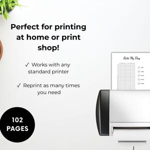 Peut inclure: Une imprimante noir et blanc imprimant un tableau "Rate My Day". L'image comprend le texte "Parfait pour l'impression &agrave; la maison ou en imprimerie !" et "102 PAGES". Une tasse de caf&eacute; et une petite plante sont &eacute;galement visibles.