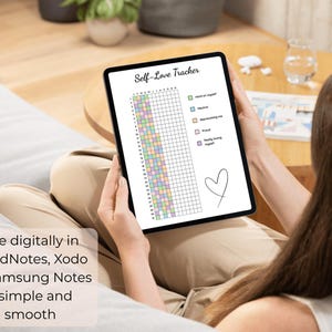 Peut inclure: Une tablette affiche un suivi num&eacute;rique de l'amour de soi. Le suivi pr&eacute;sente une grille avec des blocs color&eacute;s et le texte "Self-Love Tracker". L'image comprend &eacute;galement le texte "Use digitally in GoodNotes, Xodo or Samsung Notes - simple and smooth."