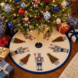 May include: A round cream-colored Christmas tree skirt featuring a repeating pattern of blue and white nutcrackers holding peppermint candies and green Christmas trees in blue and white planters, finished with a dark blue border trim.
