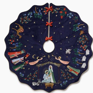 May include: A circular navy blue velvet Christmas tree skirt with a scalloped edge and three red ribbon ties. The design features embroidered nativity scenes, including the holy family, angels, wise men, a camel, sheep, and a dove, with gold stars.