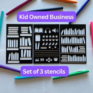 May include: Set of 3 black stencils with white cut-out designs, including bookshelves, books, and reading-themed icons. The text "Kid Owned Business" and "Set of 3 stencils" are displayed on purple banners. Colorful pens surround the stencils.