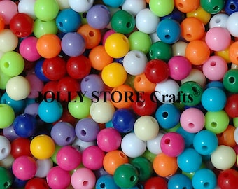 May include: A large assortment of colorful plastic beads. The beads are round and have a hole in the center. The beads are in a variety of colors, including red, orange, yellow, green, blue, purple, and pink.