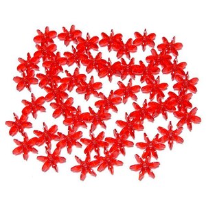 May include: A large group of red plastic flower-shaped embellishments. The embellishments are scattered on a white background.