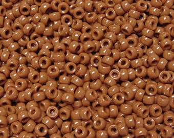 Op de afbeelding: Een close-up van een grote hoeveelheid bruine plastic kralen. De kralen zijn rond en hebben een gladde, glanzende afwerking.