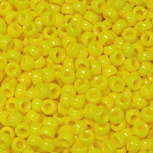 May include: A close-up shot of numerous bright yellow pony beads. The beads are cylindrical with a large hole running through the center. The beads are smooth and glossy, reflecting light. These beads are commonly used for jewelry making and crafts.