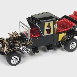 May include: A black and gold toy car with a carriage-like body and a powerful engine. The interior is red, and the wheels are black with silver rims. The car has a unique, vintage design.